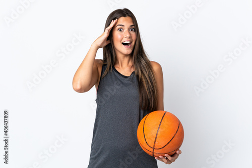 Young brazilian woman playing basketball isolated on white background with surprise expression © luismolinero