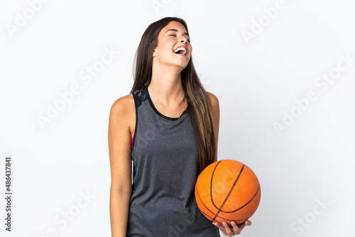 Young brazilian woman playing basketball isolated on white background laughing © luismolinero