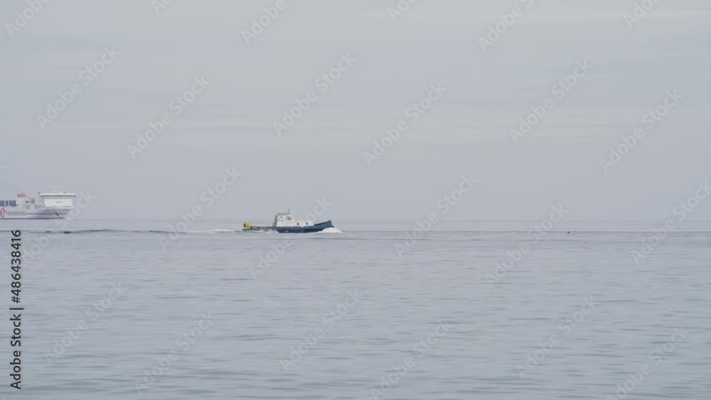 A small fishing vessel sailing off in front of a big passenger ship. This was filmed in Palermo Italy. A small fishing vessel sailing off in front of a big passenger ship. This was filmed in Palermo Italy.
