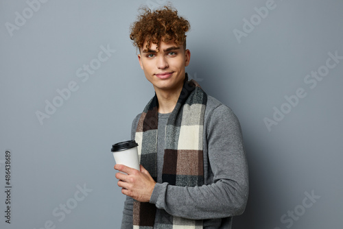 handsome young man checkered scarf posing drink mug light background