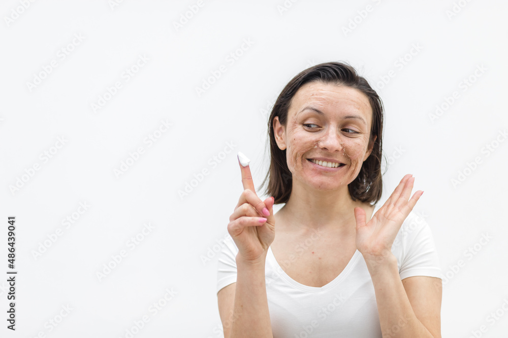 Photo of smiling woman with dry skin showing finger in a cream. Photo of smiling woman with dry skin showing finger in a cream.