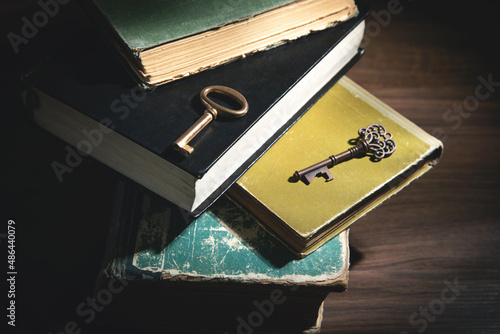 Books and old keys on the wooden table.