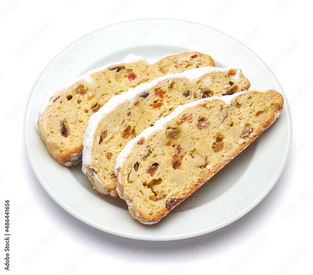 Slices of Traditional Christmas stollen cake with marzipan and dried fruit isolated on white ceramic palte