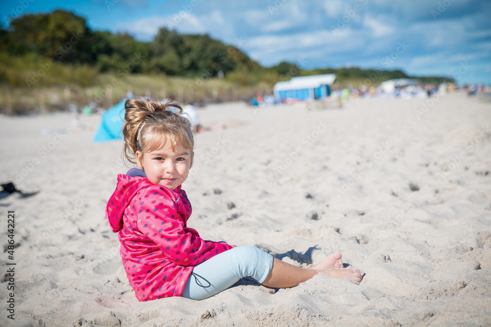 Little girl is sitting on the beach near Hel city. Poland Little girl is sitting on the beach near Hel city. Poland