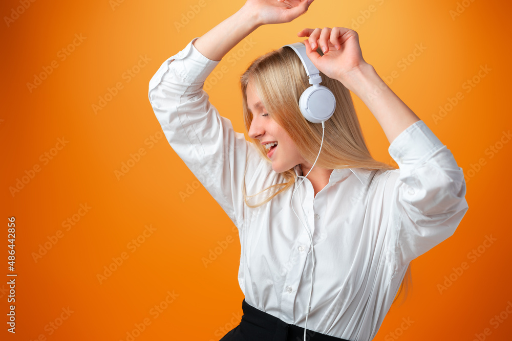 Portrait of modern happy teen school girl with headphones on orange background Portrait of modern happy teen school girl with headphones on orange background