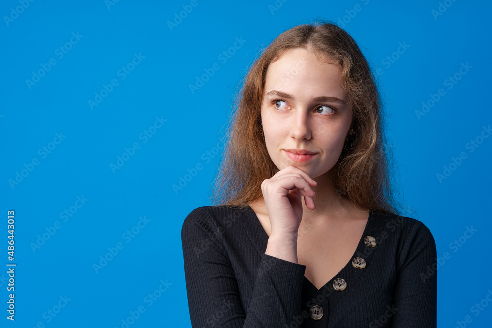 Portrait of pretty teen girl thinking and creating solution against blue background