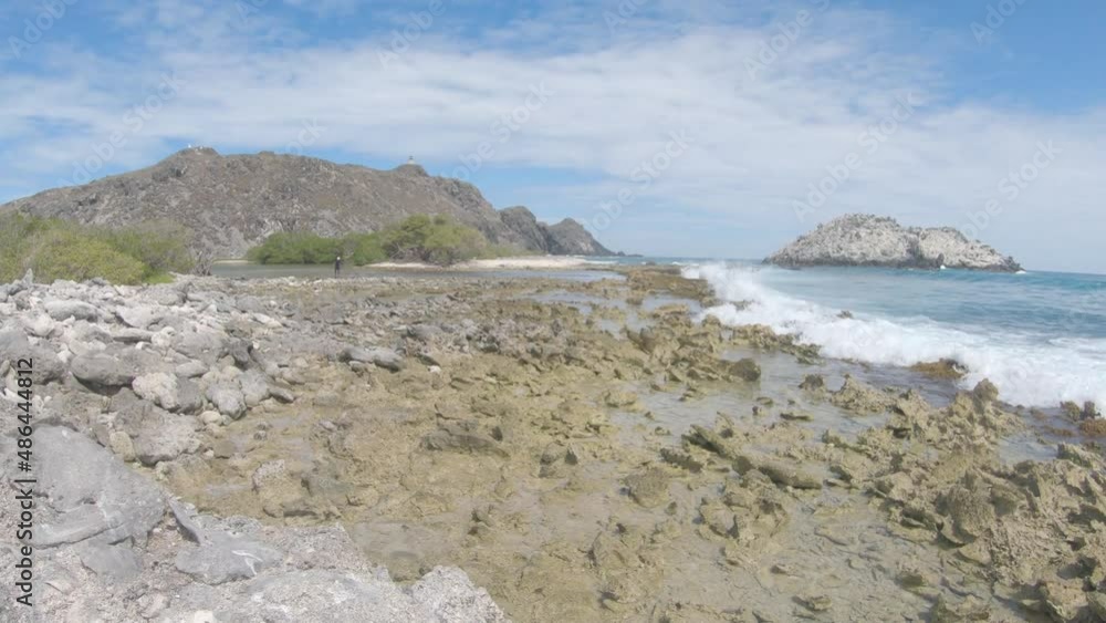 Panning Scenic Shot Of storm rock barrier. Beach waves splash breaking against the rocks Landscape los Roques Venezuela. Panning Scenic Shot Of storm rock barrier. Beach waves splash breaking against the rocks Landscape los Roques Venezuela.