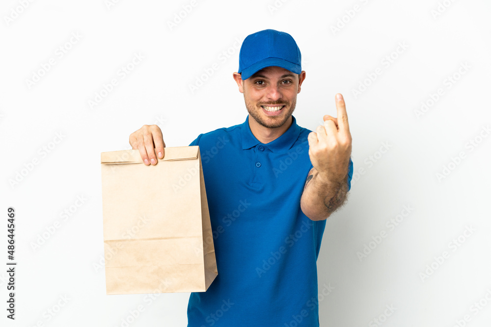 Brazilian taking a bag of takeaway food isolated on white background doing coming gesture Brazilian taking a bag of takeaway food isolated on white background doing coming gesture
