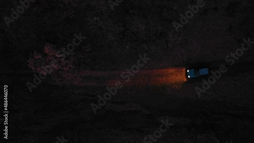 Aerial view of a car on dirt road in the forest