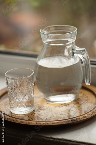 Jug of water and a glass on the windowsill.