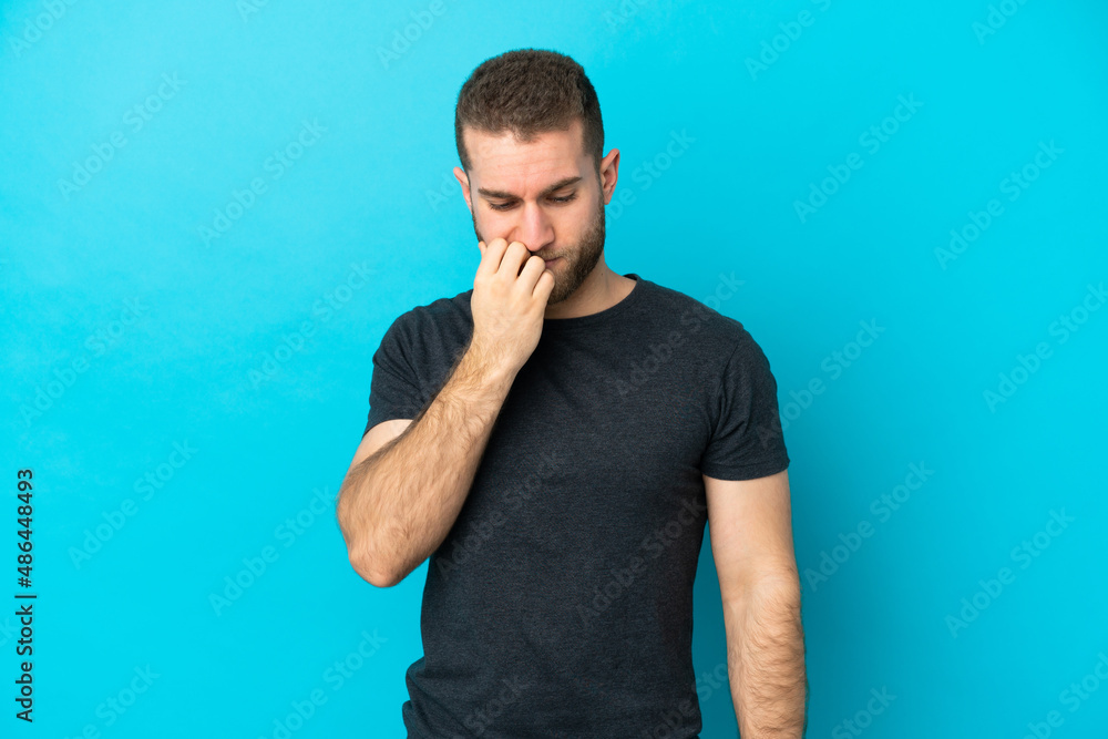 Young handsome caucasian man isolated on blue background having doubts