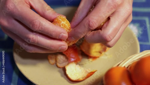 Man peeling a tangerine with hands. Healthy food concept