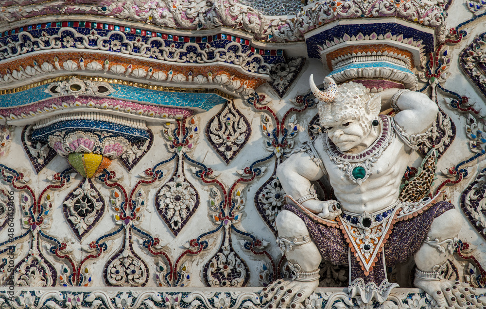 Elaborate sculptures of monster is made of bricks and mortar, decorated with various colored glazed tiles at the chapel of The Pariwas Ratchasongkram temple. Selective Focus.