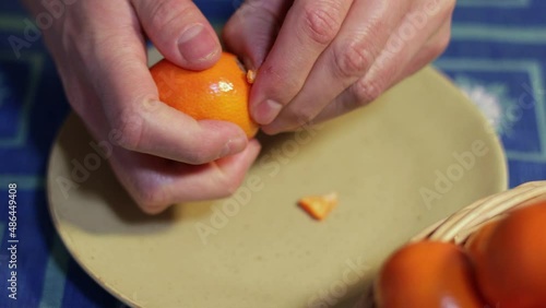 Man peeling a tangerine with hands. Healthy food concept