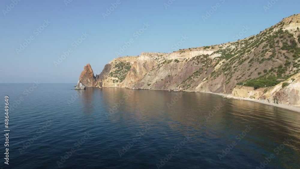 Aerial view from above on calm azure sea and volcanic rocky shores. Small waves on water surface in motion blur. Nature summer ocean sea beach background. Nobody. Holiday, vacation and travel concept Aerial view from above on calm azure sea and volcanic rocky shores. Small waves on water surface in motion blur. Nature summer ocean sea beach background. Nobody. Holiday, vacation and travel concept