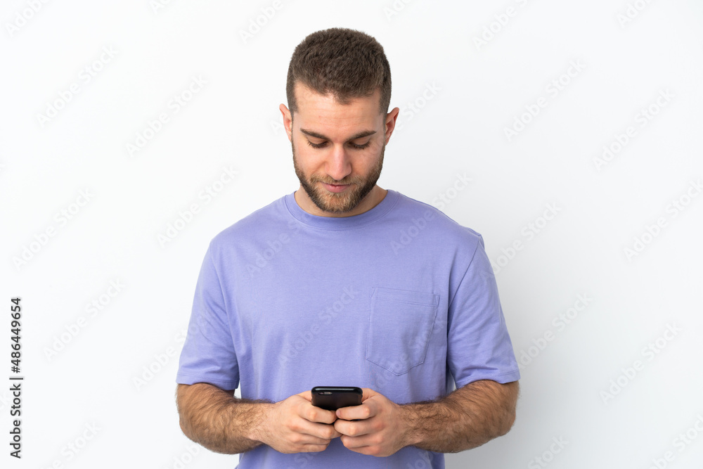 Young handsome caucasian man isolated on white background using mobile phone Young handsome caucasian man isolated on white background using mobile phone