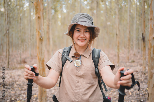 Asian woman hiking trail and trekking in the forest alone. Travel and outdoor activity. Relax and recreation in autumn holiday. photo