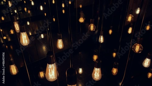 Flickering old fashion tungsten Edison light bulb lamp over black background. Slow motion shot 4K.