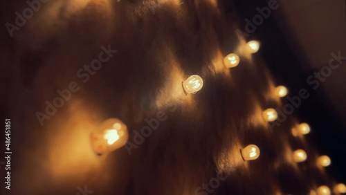 Flickering old fashion tungsten Edison light bulb lamp over black background. Slow motion shot 4K.