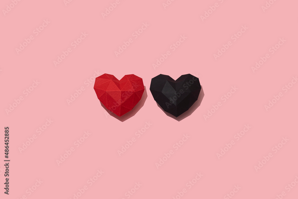 Red and black paper hearts pattern on pink background