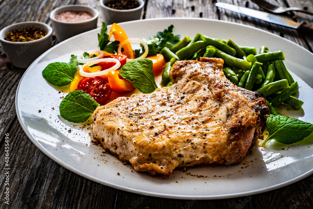 Grilled steak with boiled green bean on wooden table Grilled steak with boiled green bean on wooden table
