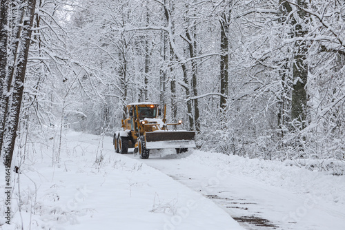 Large old snow truck driving towards camera on a winter environment.