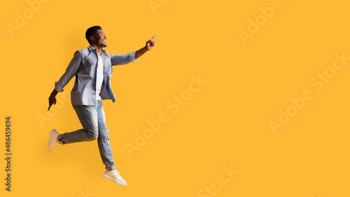Excited african american guy in denim suit showing copy space