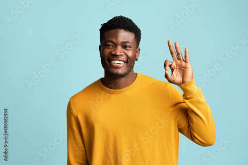 Fototapeta Cheerful african american guy showing okay gesture