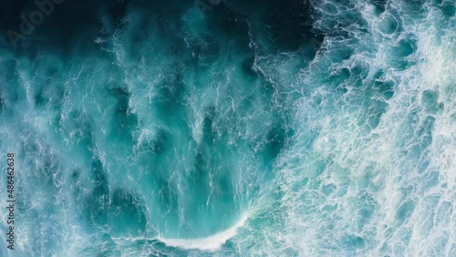 Beautiful texture of big power dark ocean waves with white wash. Aerial top view footage of fabulous sea tide on a stormy day. Drone filming breaking surf with foam in Indian ocean. Big swell in Bali.