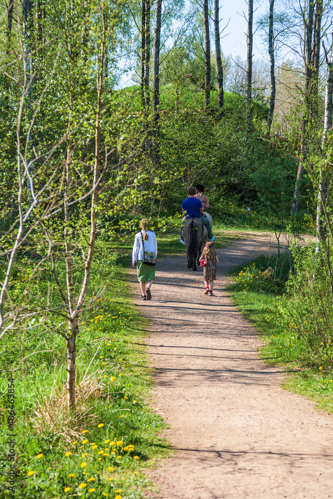 Walking path with people riding horses and walking Walking path with people riding horses and walking