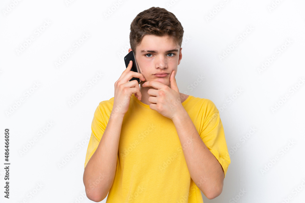 Teenager man using mobile phone isolated on white background thinking Teenager man using mobile phone isolated on white background thinking