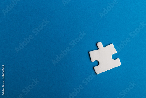 Jigsaw puzzle piece on blue background.