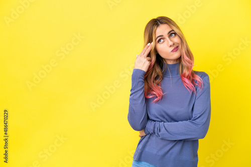 Young woman over isolated yellow background with problems making suicide gesture © luismolinero