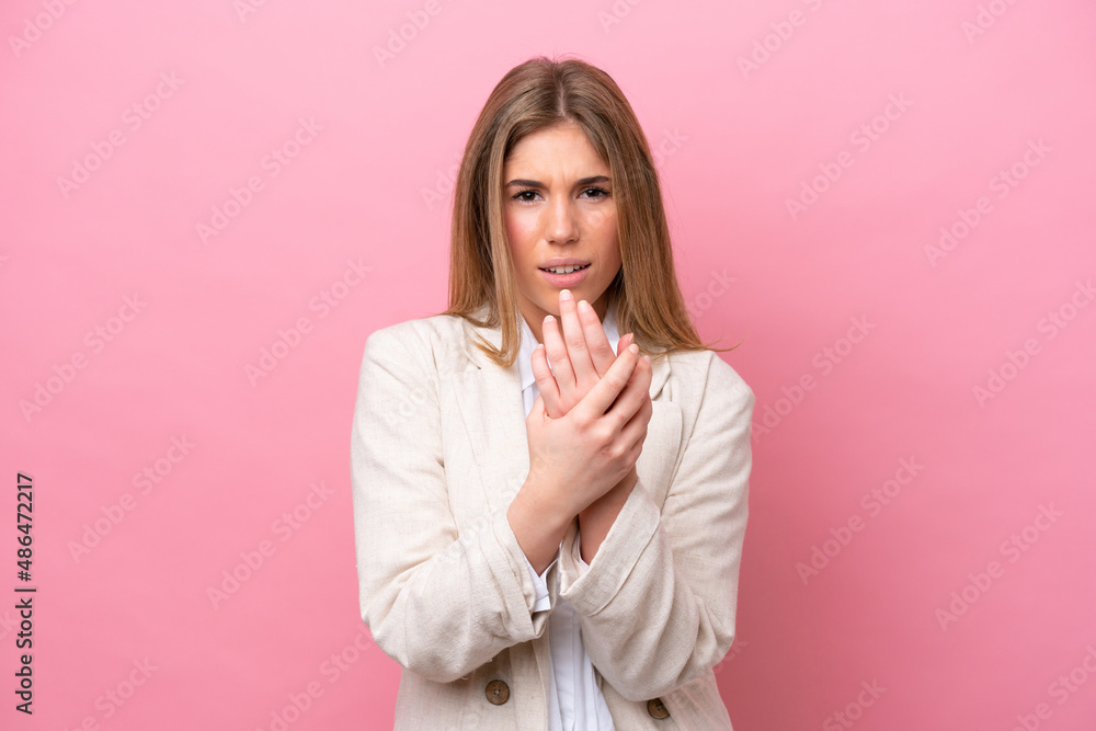 Young caucasian woman isolated on pink bakcground suffering from pain in hands Young caucasian woman isolated on pink bakcground suffering from pain in hands