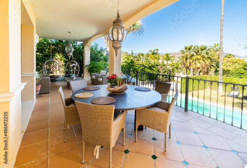 a view overlooking a villa pool from the dining terrace area with blue skies 