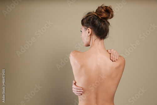 Fotografía Back view of woman with perfect smooth skin on beige background, space for text