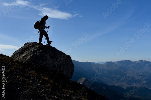 mountaineer walking alone in peak mountains