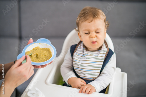 Angry baby boy doesn't want to eat.