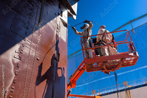 Painters painting a ship at a shipyard photo