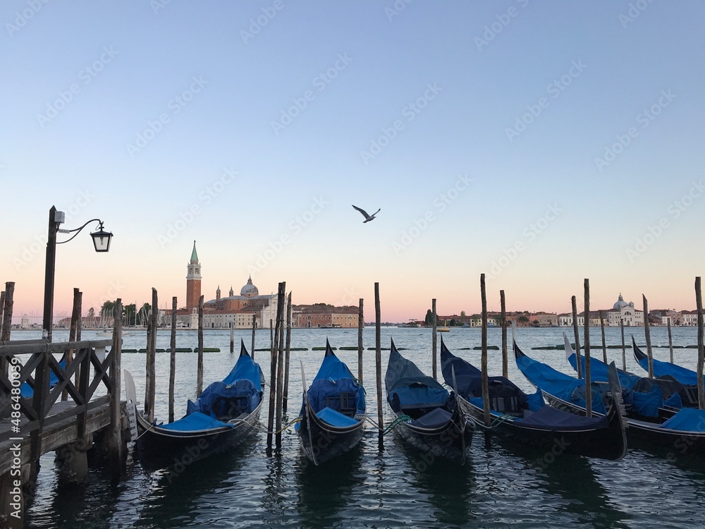 View of Venetian gondolas in Venice lagoon during sunset in Venice, Italy.