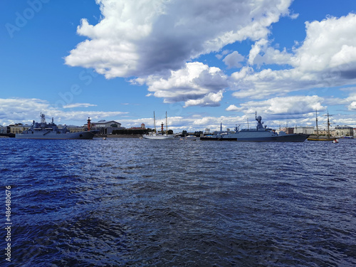 Warships, frigates and sailboats built in the Neva water area for the Day of the Navy in St. Petersburg, there are many pleasure boats around.