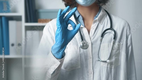 Close-up docor showing hand gesture symbol everything will be alright ok. Sign ok showing doctor's hand in blue blue glove. Medical office worker at hospital
 photo