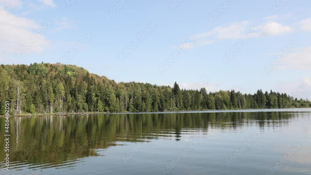 beautiful view from the lake to the forest. blue water and trees in summer. Russian village. Beautiful forest lake in Russia. Panoramic view of beautiful lake landscape. beautiful view from the lake to the forest. blue water and trees in summer. Russian village. Beautiful forest lake in Russia. Panoramic view of beautiful lake landscape.
