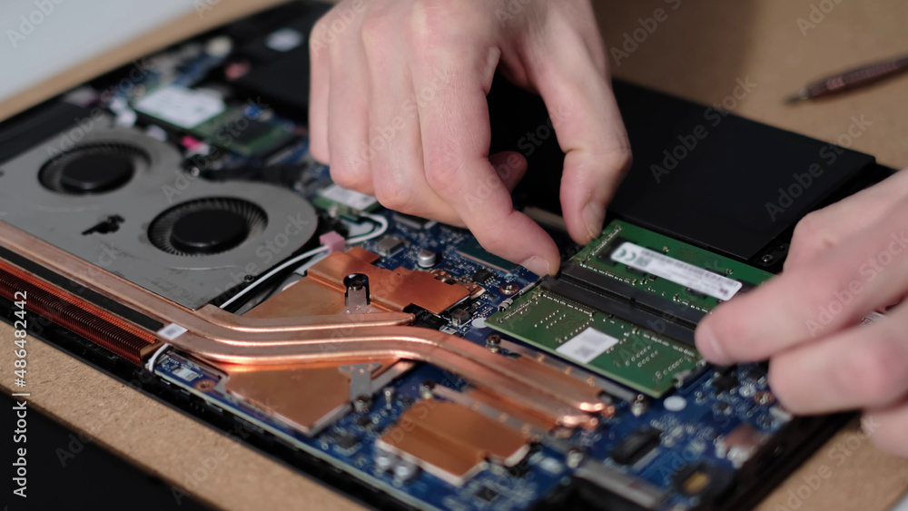 Unrecognizable engineer pulls out the RAM. Electronic renovation, business, occupation concept Unrecognizable engineer pulls out the RAM. Electronic renovation, business, occupation concept