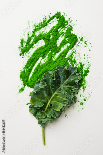 Green leaf of kale and kale powder on white background.