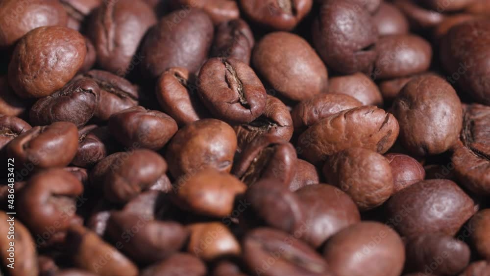 background of roasted coffee beans falling from above while frying in a frying pan, close-up background of roasted coffee beans falling from above while frying in a frying pan, close-up