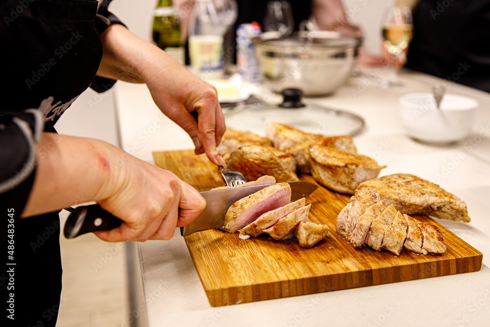 The chef is cutting the turkey fillet.