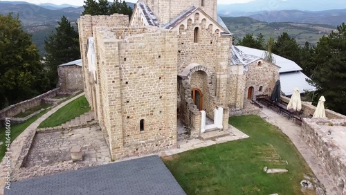10 an old medieval stone monastery on top of a mountain hidden in a forest surrounded by large walls