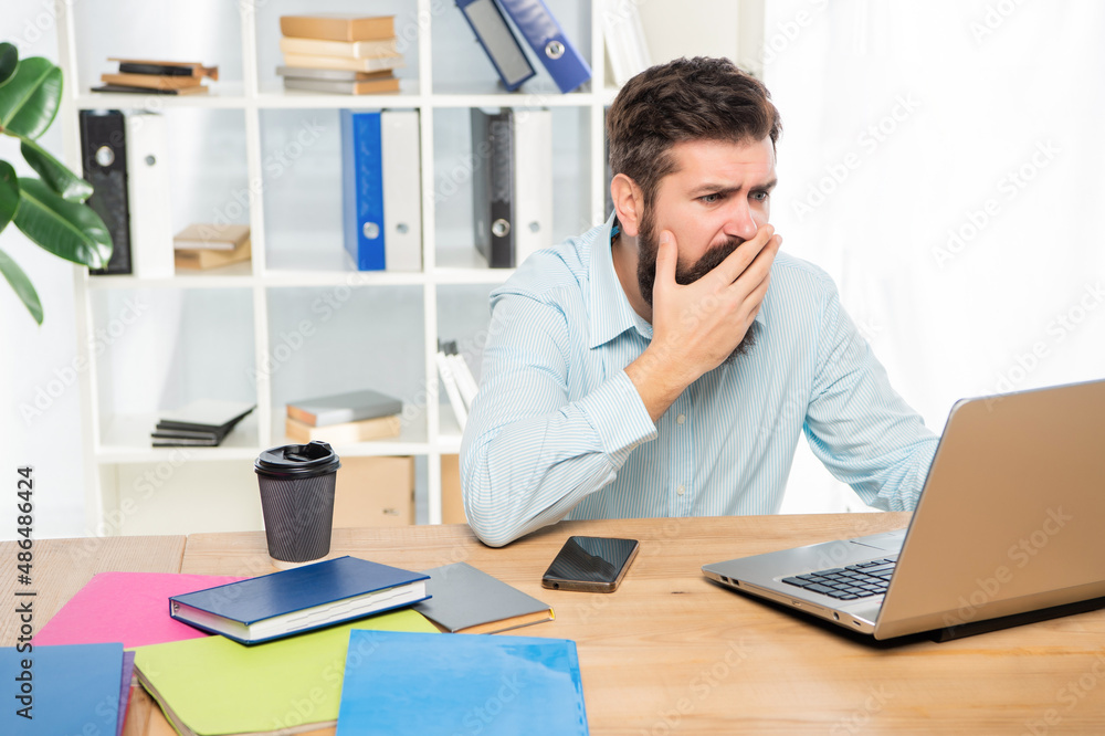 Stressed businessman working on laptop at office desk, stress Stressed businessman working on laptop at office desk, stress
