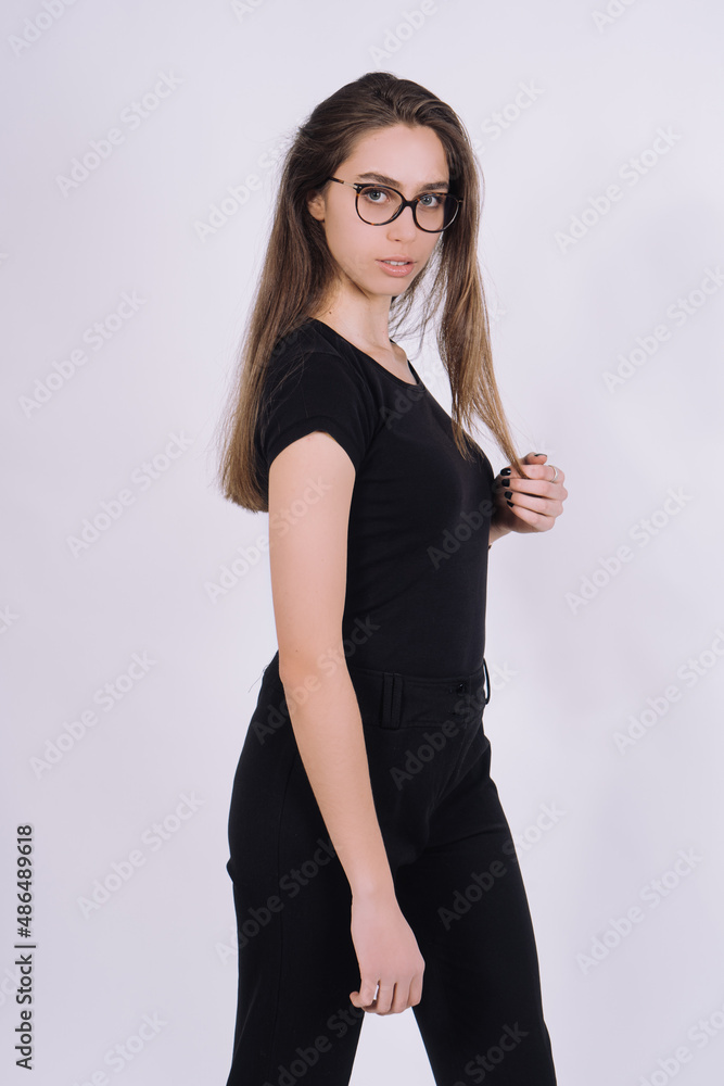 Young Female model in studio. high fashion portrait of young elegant woman. skinny black pants, black heels shoes. Young Female model in studio. high fashion portrait of young elegant woman. skinny black pants, black heels shoes.